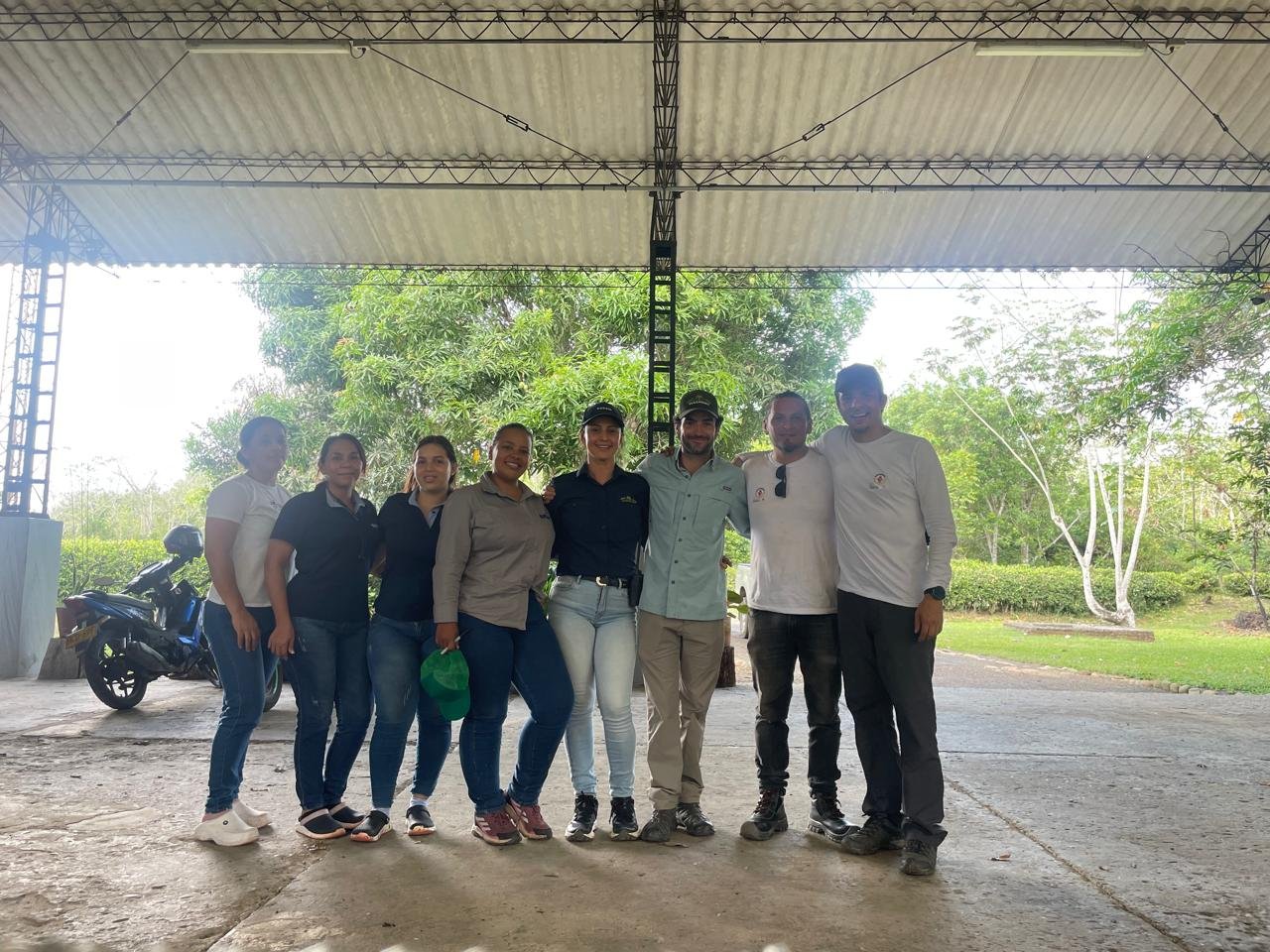 Equipo de trabajo del programa reunido bajo una zona techada de la hacienda